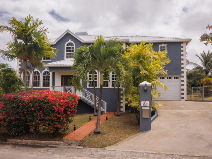 Positioned in the sought-after neighbourhood of Pleasant Hall, St. Peter, Villa of Light is a spacious two-storey home just moments from the charming town of Speightstown — offering easy access to beautiful beaches, everyday essentials, and a relaxed North Coast lifestyle. From the moment you enter, the home makes a strong impression. A welcoming foyer opens to a sitting room on the left and an air-conditioned dining area on the right, with an elegant staircase at the centre drawing you up to the first floor. The ground floor is practical and well-proportioned, comprising a sitting room, one bedroom, a powder room, an open living and dining area, and a generously sized kitchen. A laundry room and an integral garage complete the level, while a breezy patio off the breakfast bar provides a lovely spot to start the day. Upstairs, four bedrooms offer comfortable and flexible accommodation. Two are air-conditioned, two feature private ensuite bathrooms, and a full bathroom serves the remaining rooms. The master suite is particularly impressive — a large, serene space with a substantial walk-in closet, a private balcony, a dedicated sitting or office area, and a well-appointed bathroom complete with double sinks, a shower, and a soaking tub. Outside, the property benefits from a spacious backyard — ideal for tenants looking to personalise the space — and a paved driveway that comfortably accommodates at least two vehicles alongside the single garage. The property also holds approved planning permission for a future swimming pool, adding long-term value and appeal. Villa of Light is a well-sized, comfortable home in a convenient and desirable location — well suited to a family or professional household seeking a settled base on Barbados' North Coast