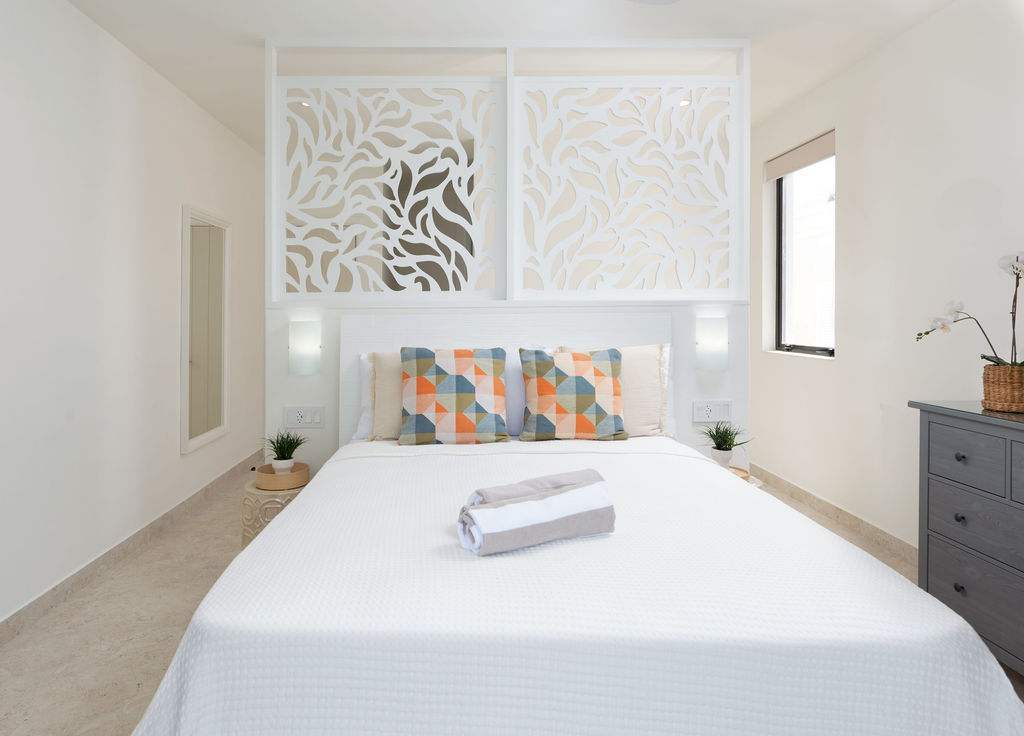 Bedroom with a patterned headboard at Calico, a beachfront villa in St James, Barbados