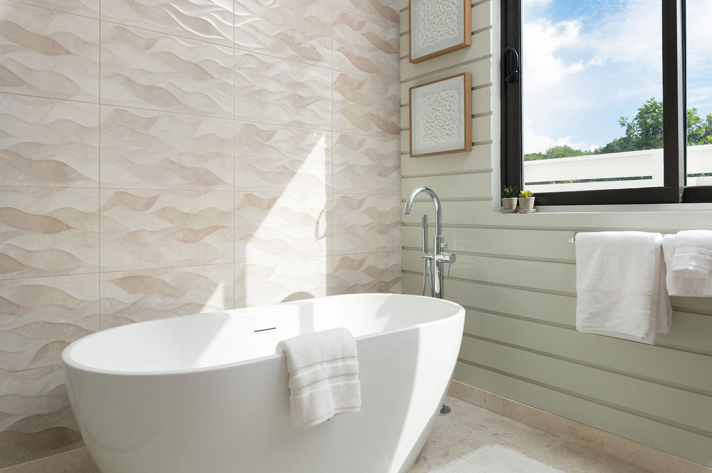 Bathroom with freestanding tub and walk-in shower at Calico, a beachfront villa in St James, Barbados