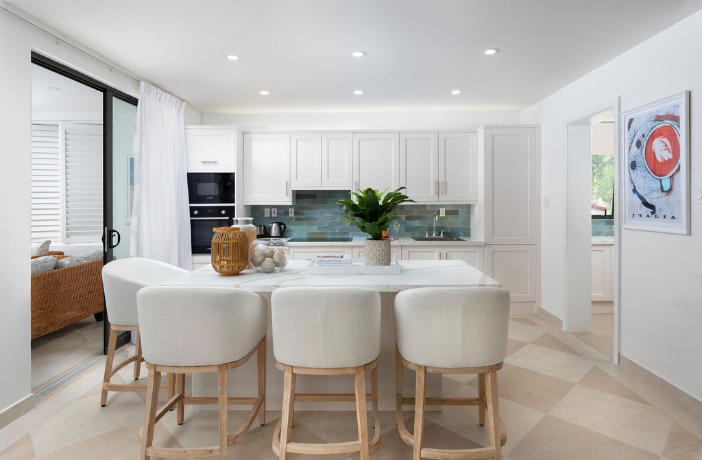 Kitchen with island and bar seating at Calico, a beachfront villa in St James, Barbados