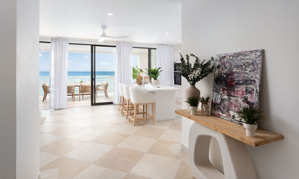 Living and dining opening to a sea-view terrace at Calico, a beachfront villa in St James, Barbados