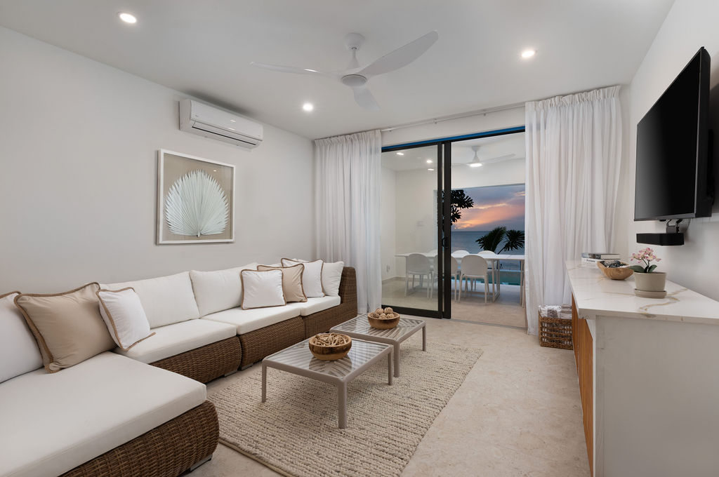 Living room with sofa opening to the terrace at Calico, a beachfront villa in St James, Barbados