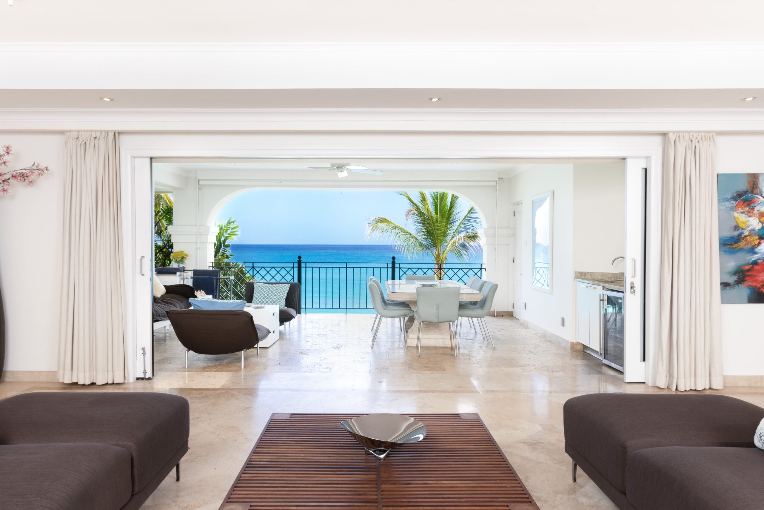 Open-plan living and dining opening to the sea-view terrace at Sandy Cove 201, St James